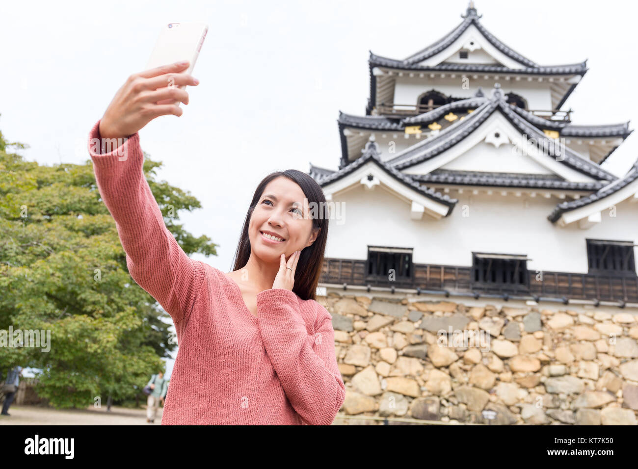 Donna asiatica tenendo selfie dal telefono mobile nel castello di Hikone Foto Stock