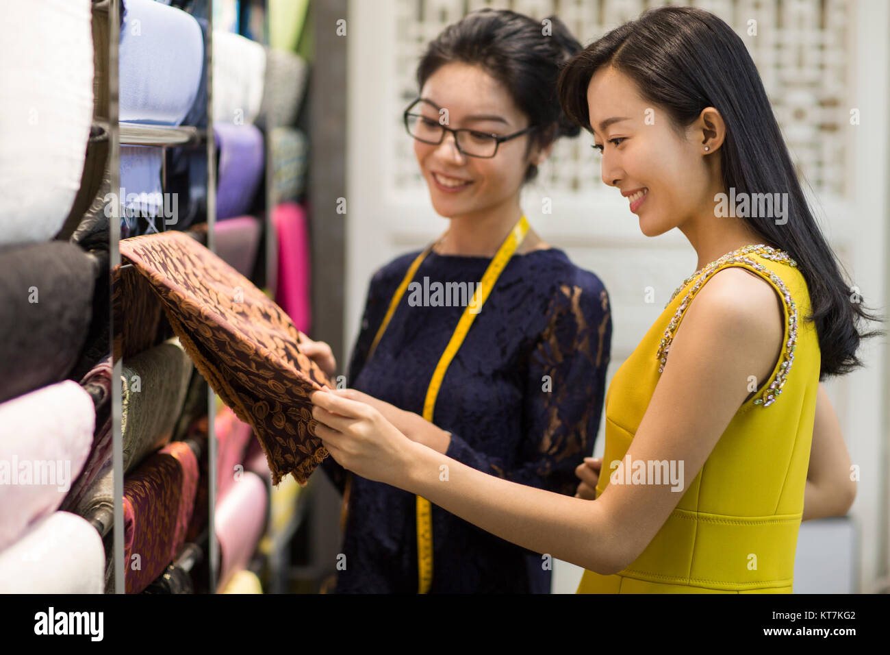 Designer di moda aiutando il cliente scelta del tessuto swatch Foto Stock