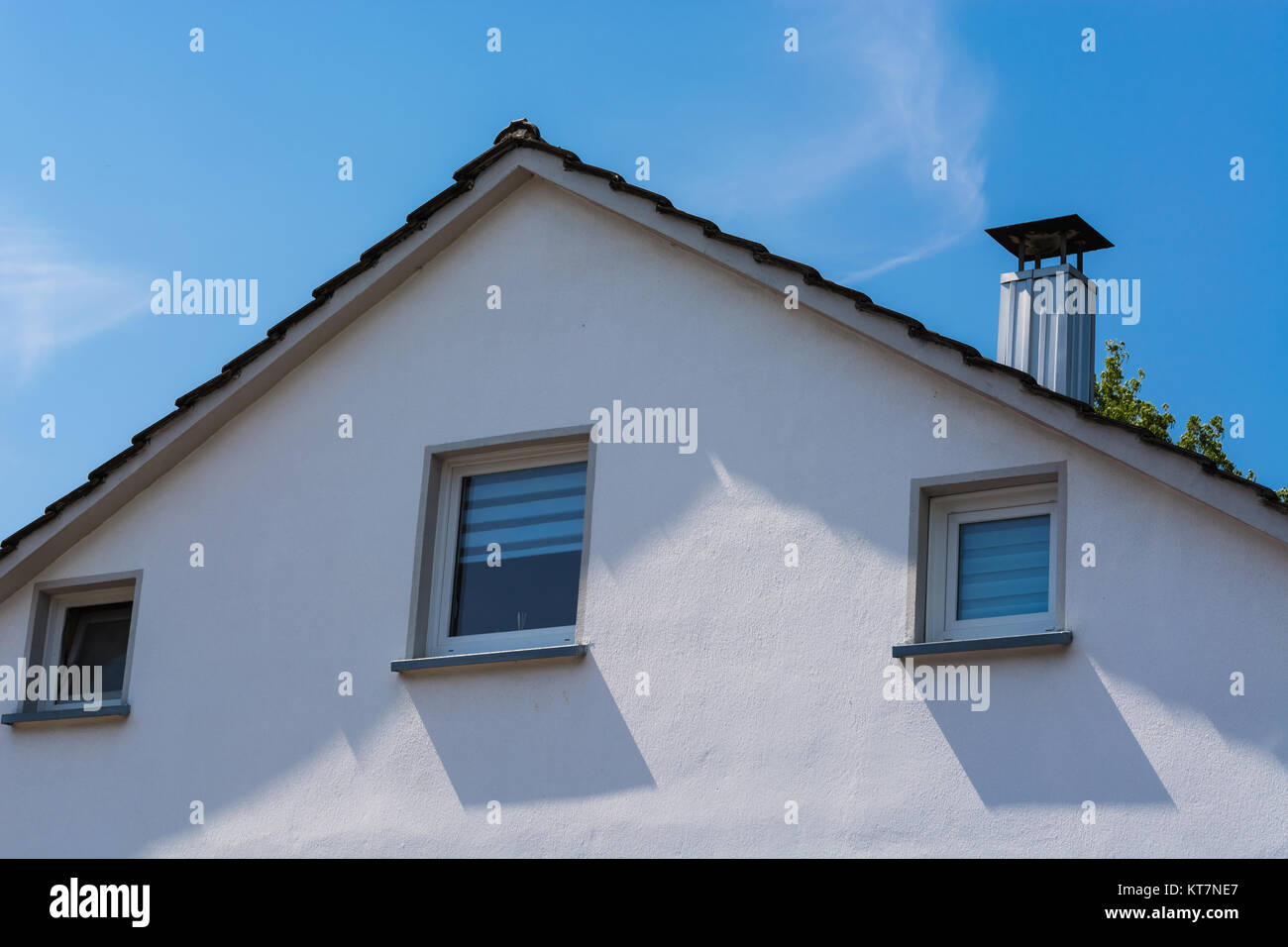 Giebelseite eines Mehrfamilienhaus der 60er Jahre vor blauen Himmel. Foto Stock