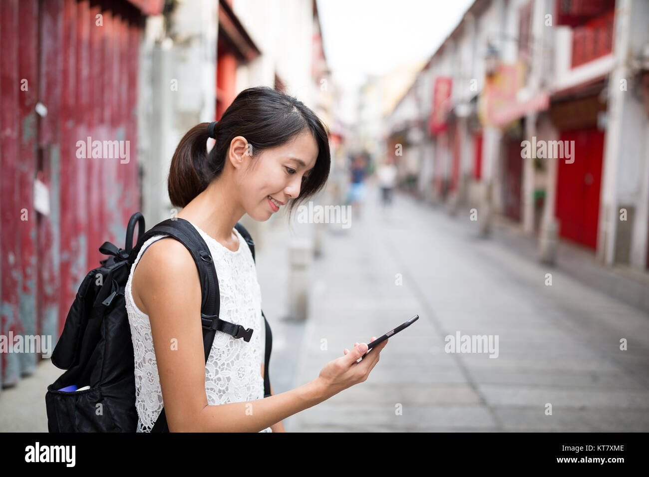 Donna che utilizza il cellulare di Macao Foto Stock