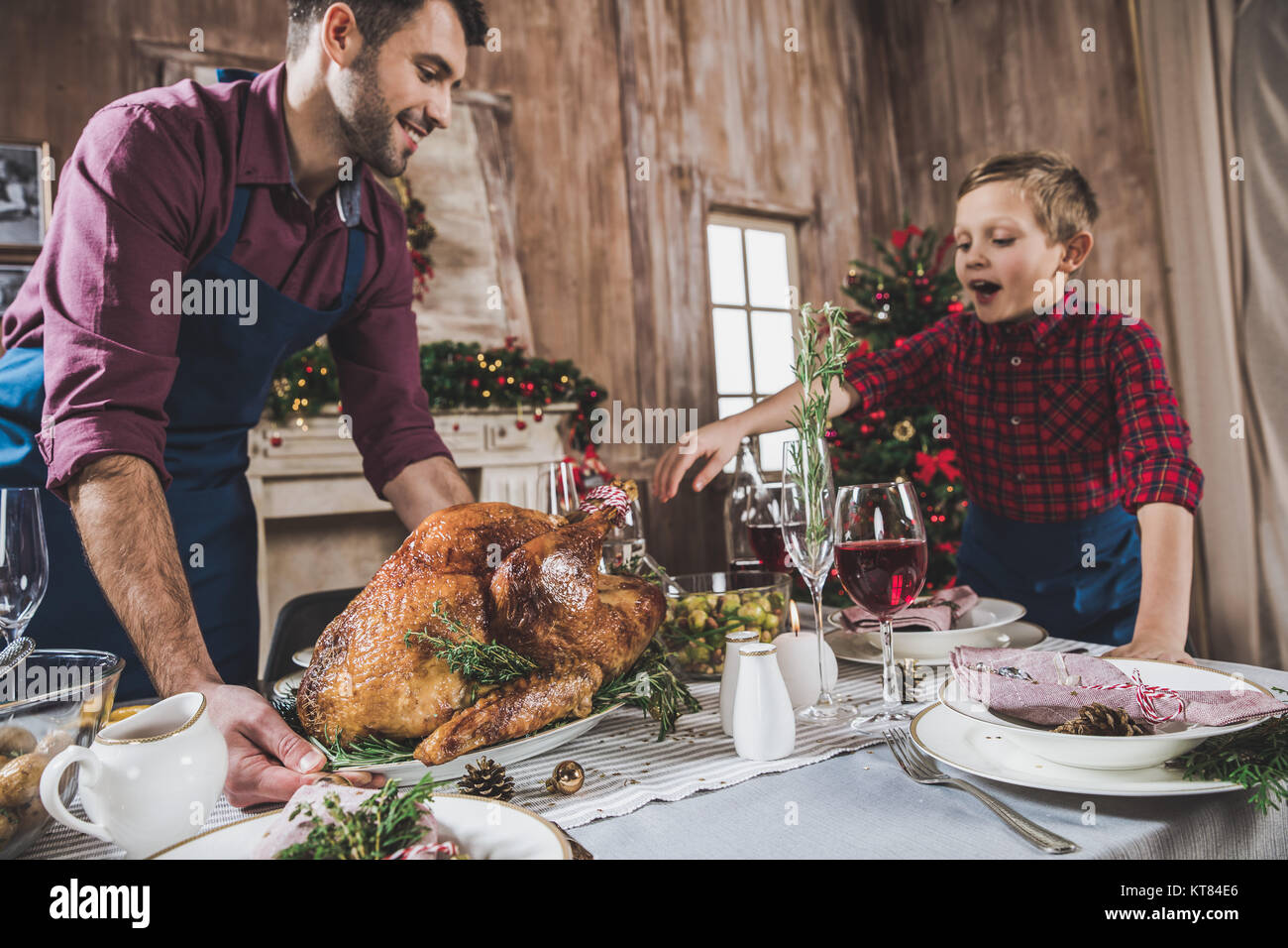 Padre e figlio che serve tavola festiva Foto Stock