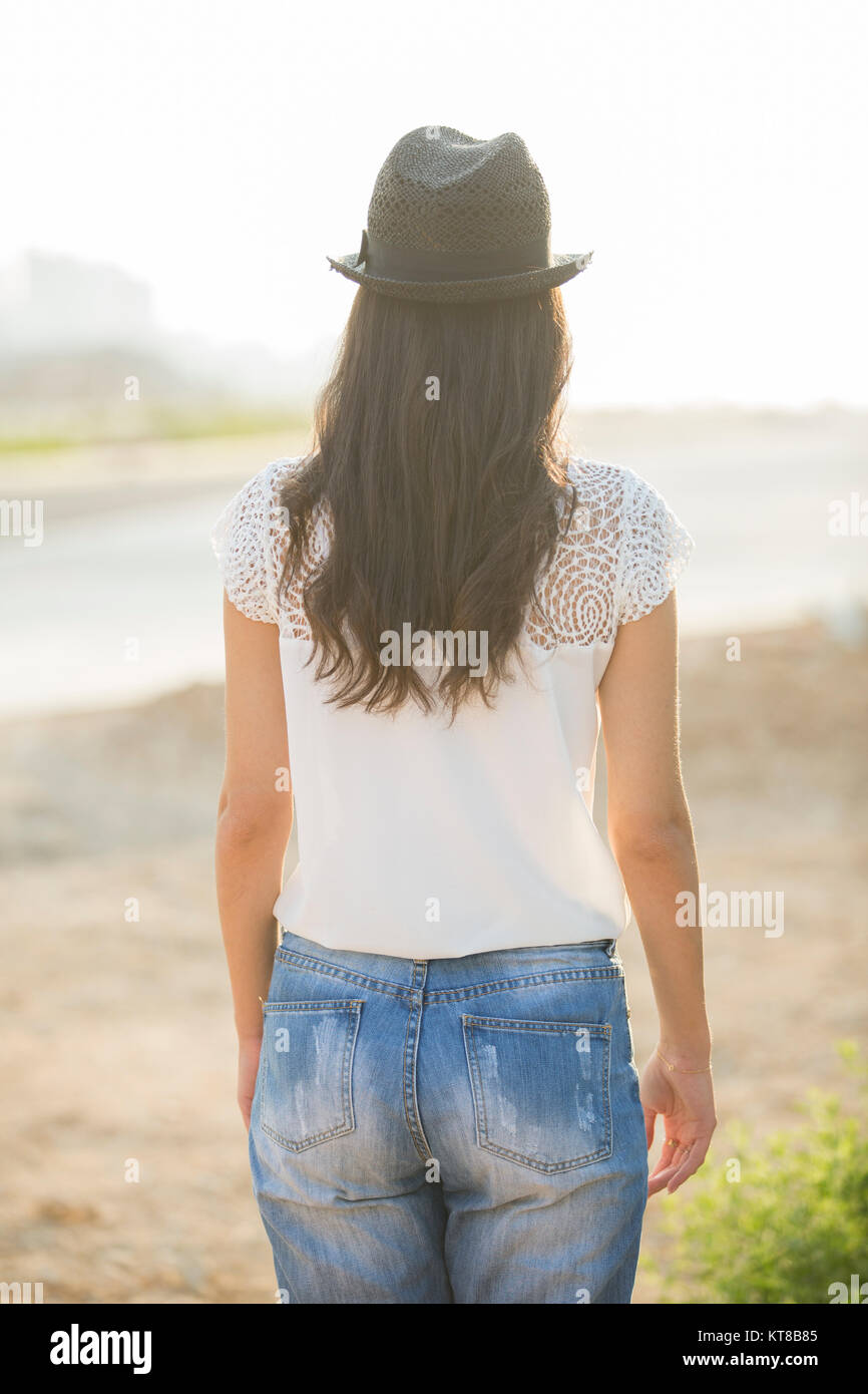 Vista posteriore di una giovane donna che indossa un cappello in piedi all'aperto Foto Stock
