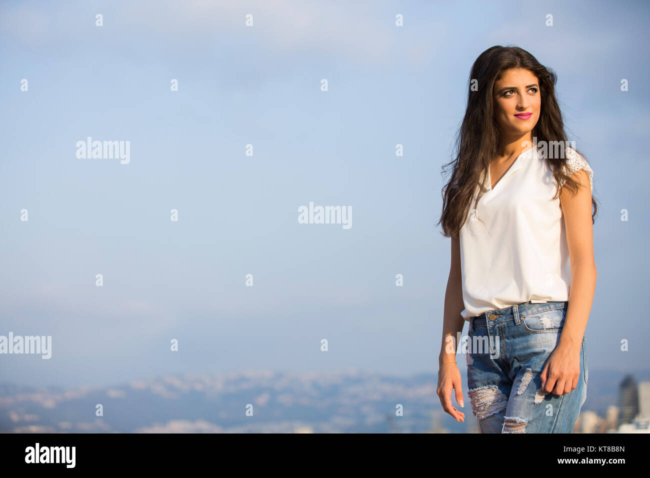 Felice giovane donna che guarda lontano sorridente Foto Stock