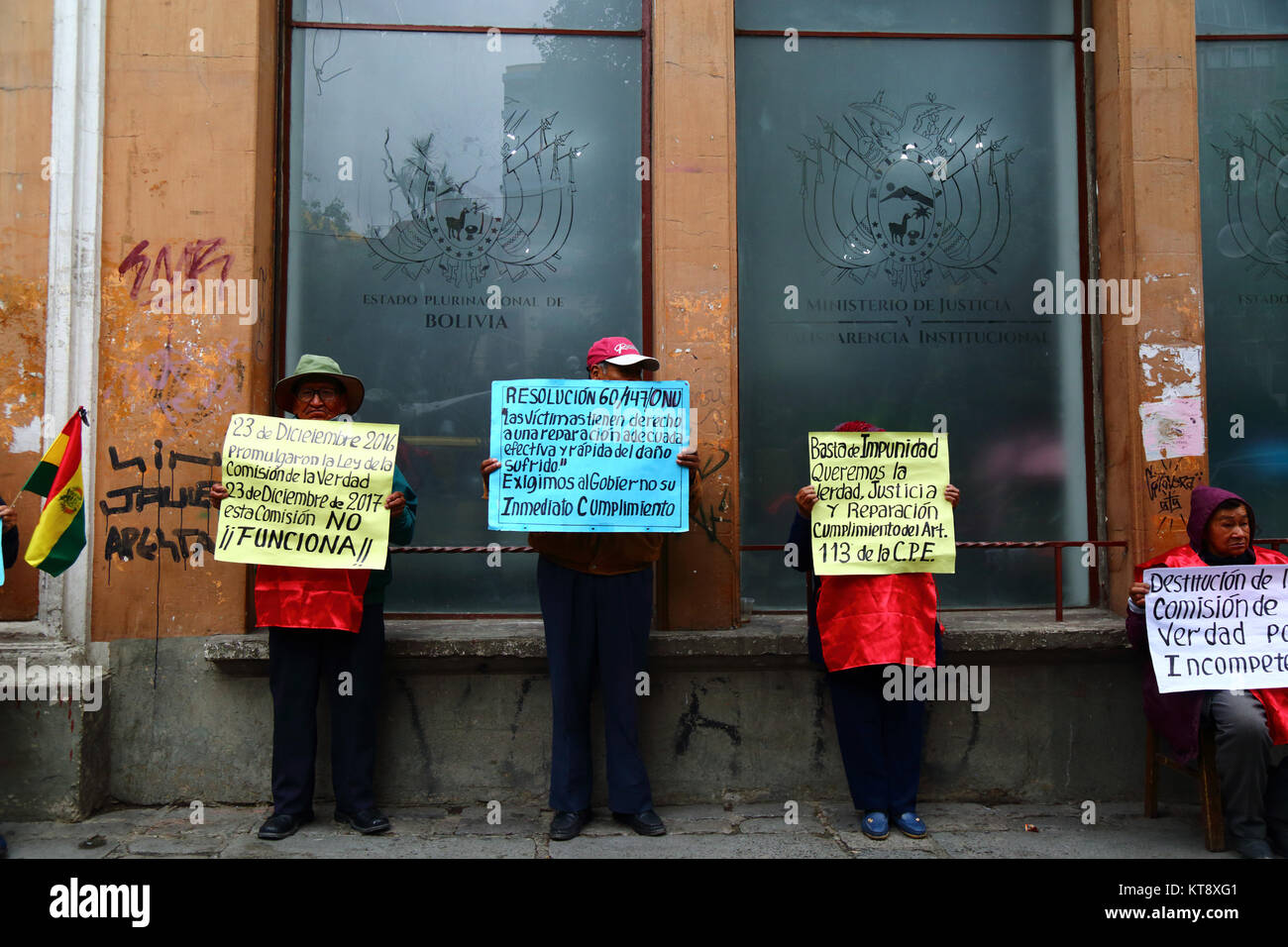 La Paz, Bolivia, 22 Dic, 2017. Vittime della Bolivia di dittature militari degli anni settanta e ottanta protestare fuori del Ministero di Giustizia edificio chiedendo giustizia e compensazione. Cartelloni preventivo risoluzione ONU 60/147 (Il diritto al risarcimento per le vittime delle violazioni del diritto internazionale in materia di diritti umani) e anche l'articolo 113 della Bolivia la Costituzione che afferma che i dipendenti pubblici che commettono reati contro lo Stato non hanno immunità da procedimenti penali. La targhetta gialla sulla sinistra è criticare la commissione Verità e Riconciliazione istituita per indagare per la sua mancanza di progressi. Credito: James Brunke Foto Stock