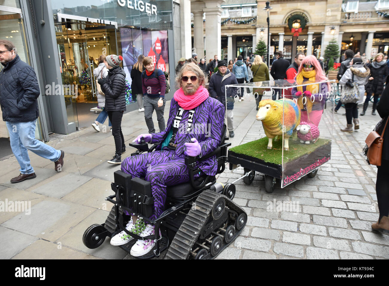 Il Covent Garden di Londra, Regno Unito. 23 Dic, 2017. Pecore per presidente stunt in Covent Garden. Descritto sul suo sito web come "il pastore è un essere umano, qualcuno come voi, ma molto più saggio. Il suo più grande successo nella vita è stata padroneggiare l'arte di non dare una battenti f*ck. Egli è un visionario, un matematico, un coltivatore, un commerciante, una procedura guidata o ciò che alcuni potrebbero chiamare "l'artista". Il pastore, un early adopter Bitcoin, visionario e realtà virtuale psichiatra sarà molto probabilmente donazione di 1 milione di euro in Bitcoin a qualcuno abbastanza presto. Forse sei tu! Credito: Matteo Chattle/Alamy Live News Foto Stock