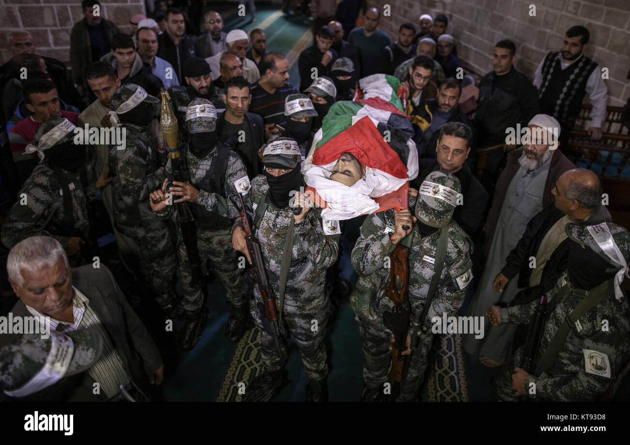 Membri armati di Abd al-Qadir al-Husayni brigate, uno dei rami militare del Fatah organizzazione, portano il corpo di 29-anno-vecchio Mohammed Mohaisen, durante una manifestazione di protesta per i funerali a Gaza City, nella Striscia di Gaza e i territori palestinesi, 23 dicembre 2017. Un giorno prima, Mohaisen è stato ucciso durante gli scontri con i soldati israeliani a seguito delle proteste contro il presidente statunitense Donald Trump per la decisione di riconoscere Gerusalemme come capitale di Israele. Foto: Wissam Nassar/dpa Foto Stock