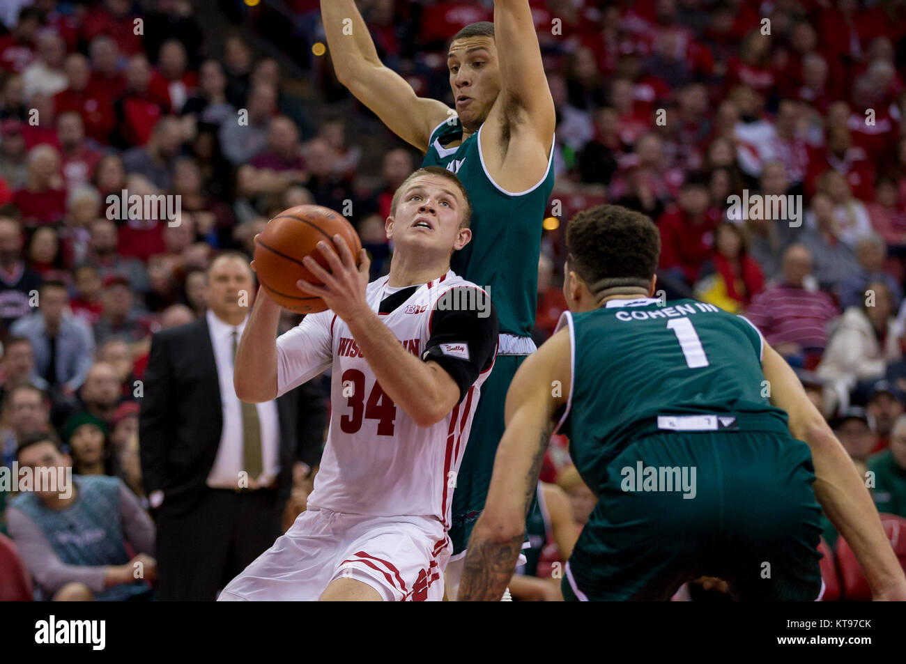 Madison, WI, Stati Uniti d'America. 23 Dic, 2017. Wisconsin Badgers guard Brad Davison #34 va per un colpo tra due difensori di Phoenix durante il NCAA pallacanestro tra la Baia Verde di Phoenix e il Wisconsin Badgers a Kohl Center a Madison, WI. Wisconsin sconfitto il Green Bay 81-60. John Fisher/CSM/Alamy Live News Foto Stock