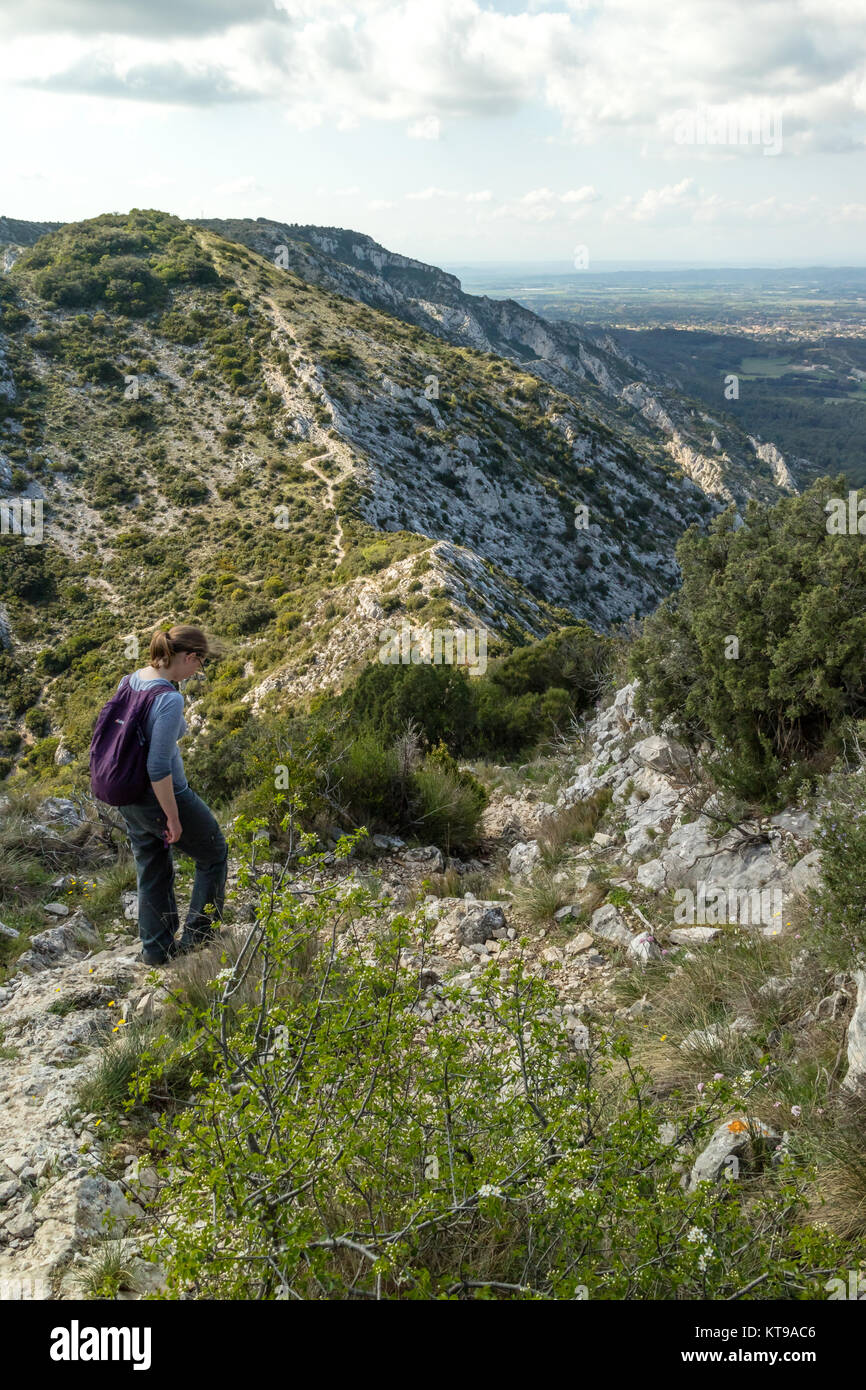 Giovane donna a piedi lungo un crinale montuoso ad Alpilles, vicino a Saint Remy de Provence, Francia Foto Stock
