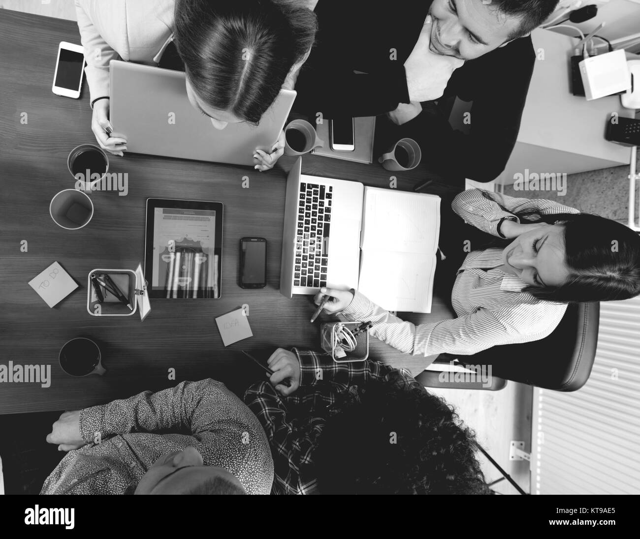 Ritratto di gruppo di avvio delle persone creative avente un incontro con un computer portatile in un ufficio moderno. La gente di affari di conversazione rilassante su nuovo p Foto Stock