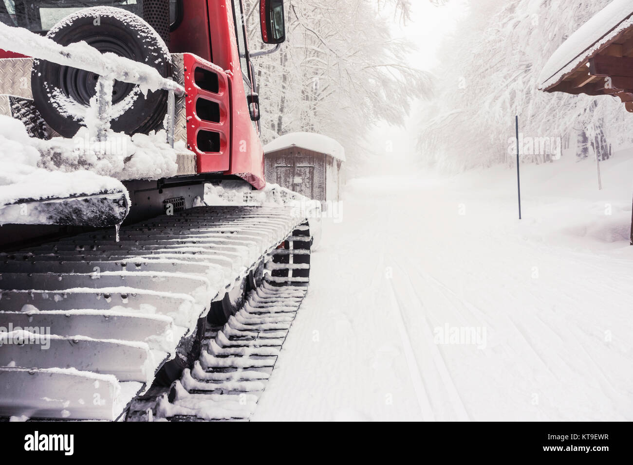 Primo piano di bruchi di snowy Snow Plough con strada coperta di neve, Vosges, Francia. Con copia spazio. Foto Stock