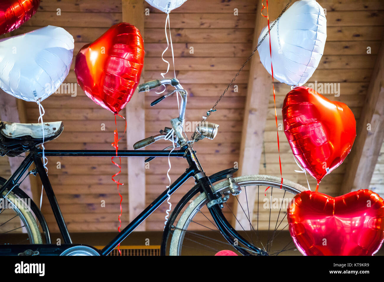 Flying bike legato al cuore di palloncini sagomati Foto Stock