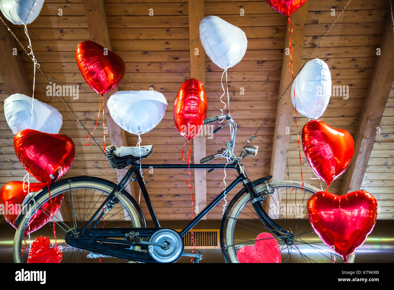 Flying bike legato al cuore di palloncini sagomati Foto Stock