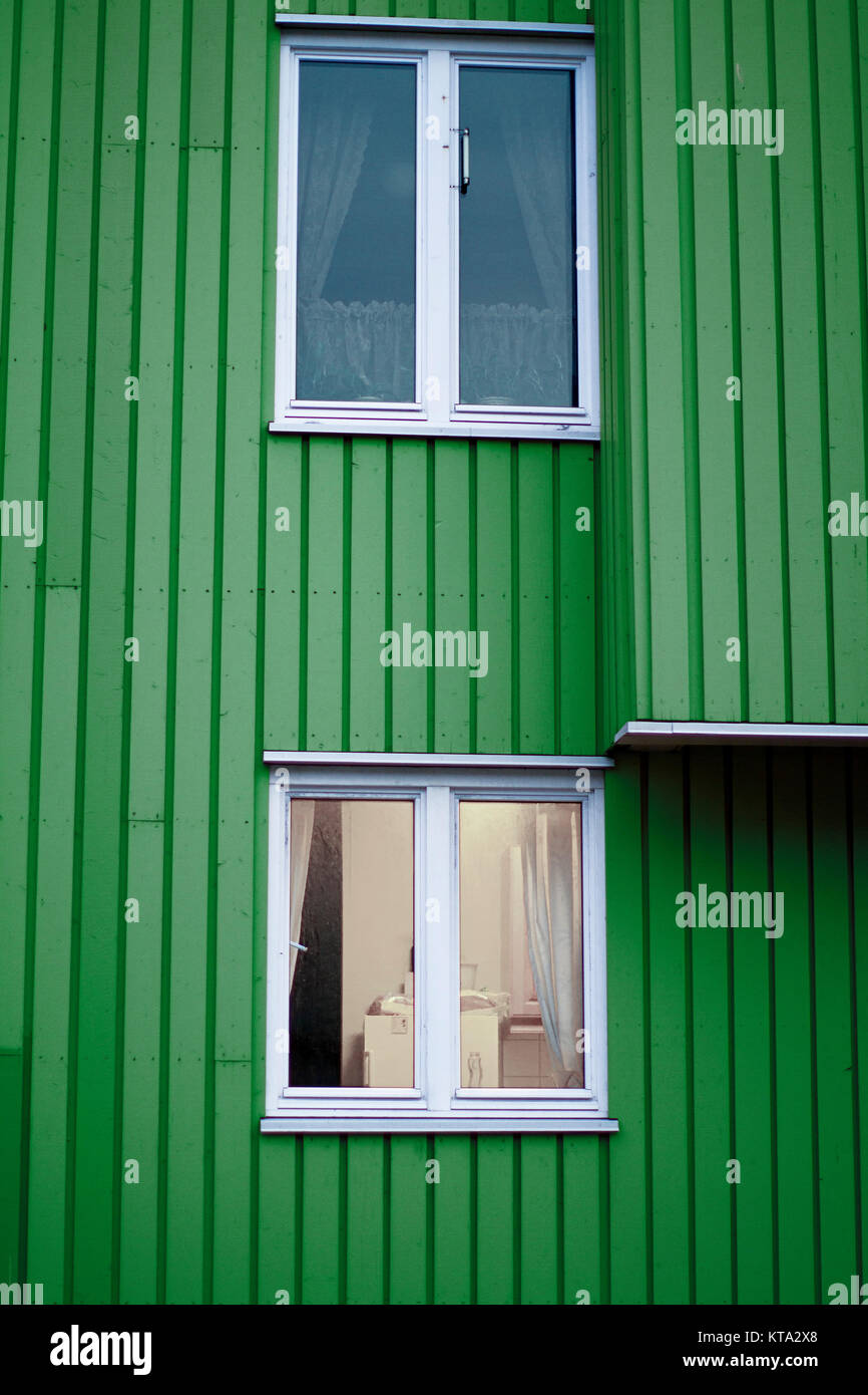 Parete Verde casa in legno due finestre bianche Foto Stock
