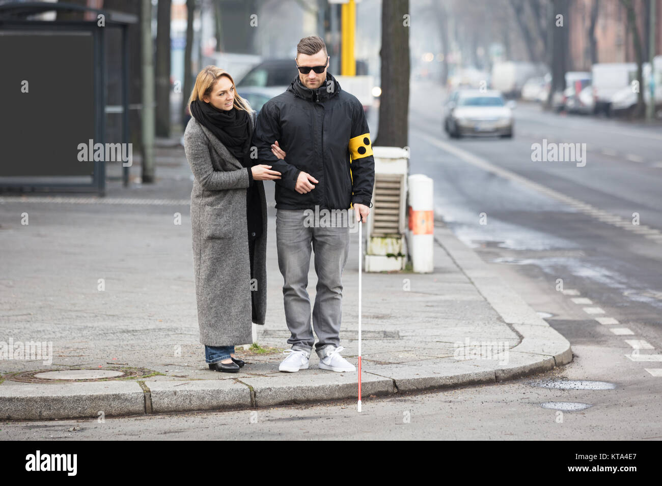 La donna che assiste cieco su strada Foto Stock