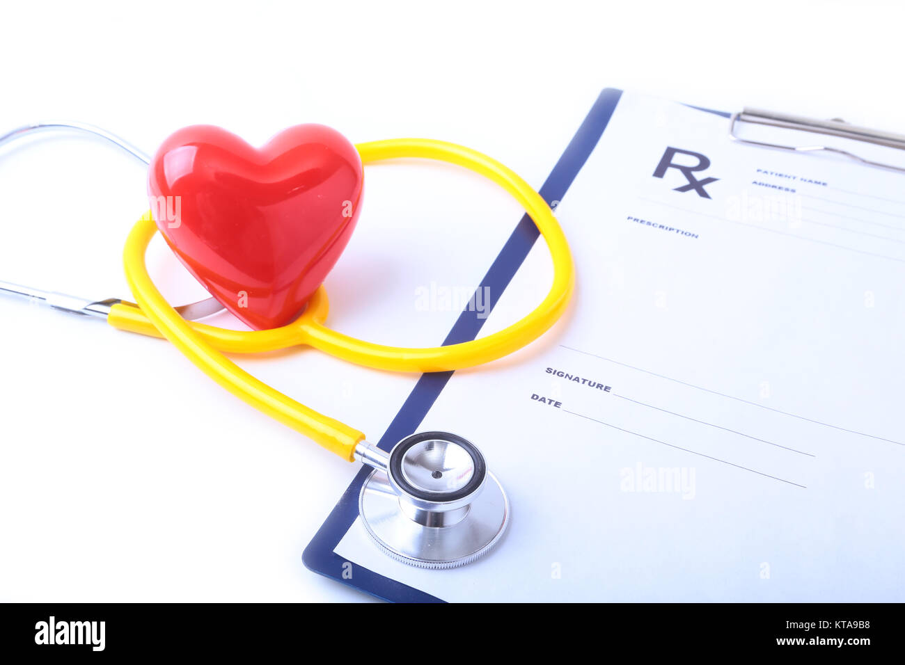 Un cuore con un medico di uno stetoscopio isolato su sfondo di legno Foto Stock