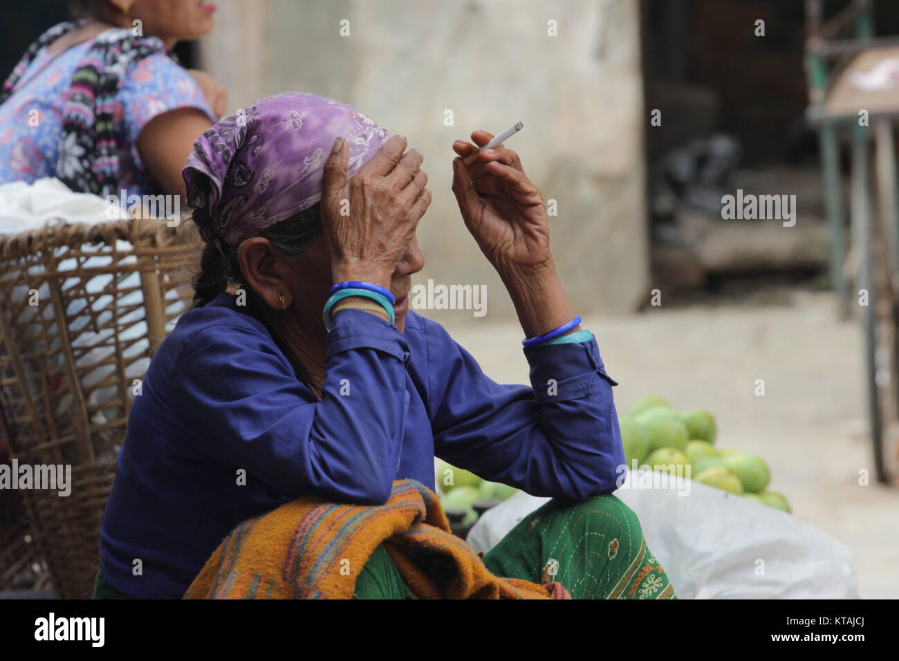 Un venditore vegetali a New Road Kathmandu parlando il riposo dal lavoro Foto Stock