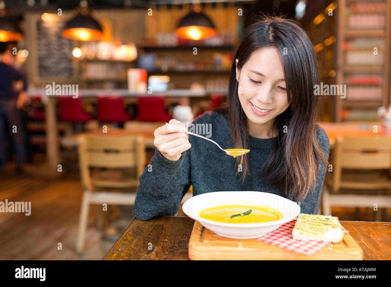 Donna godere della sua minestra in crema in ristorante Foto Stock