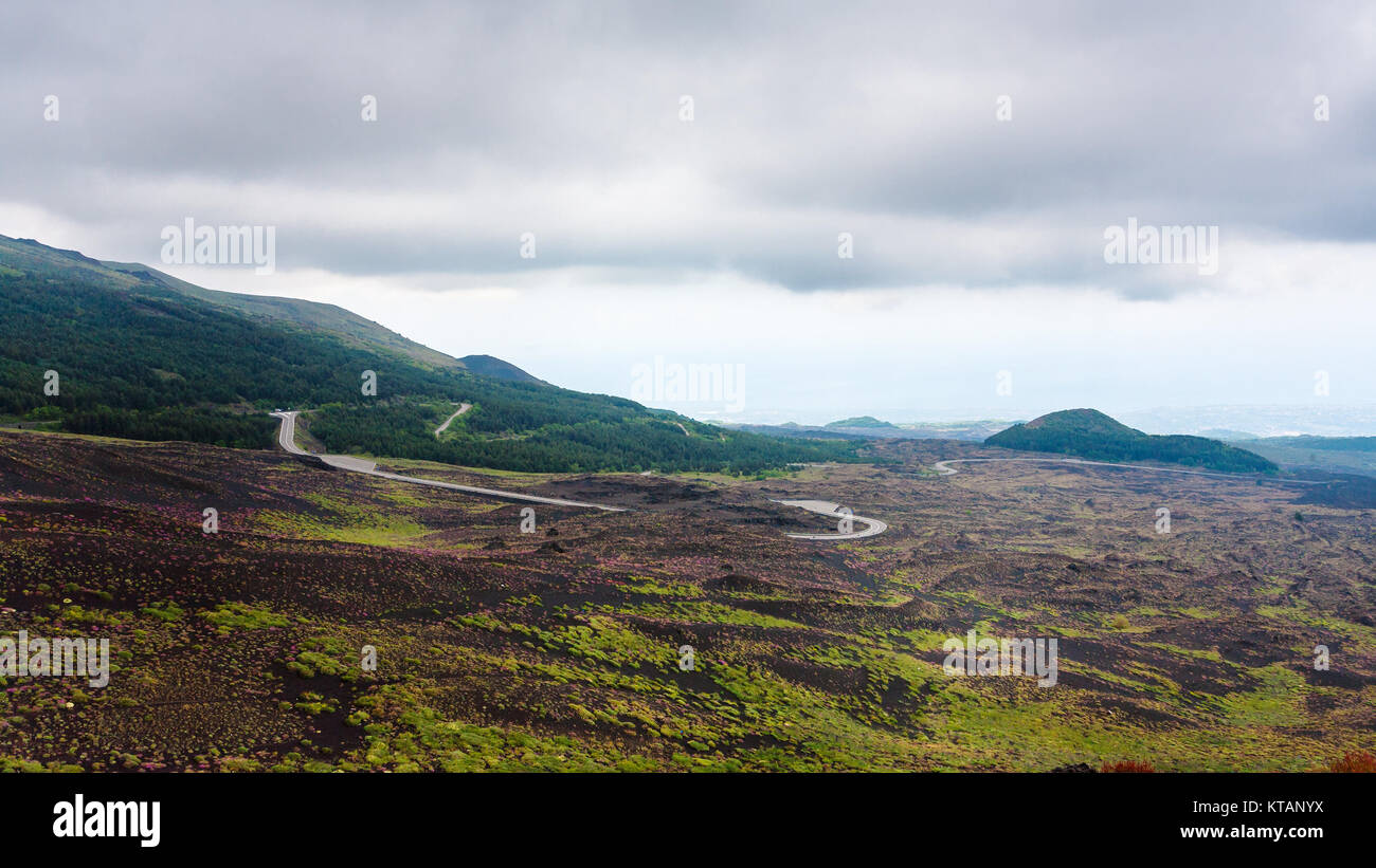 Cielo nuvoloso su strada in campi di lava sul Monte Etna Foto Stock