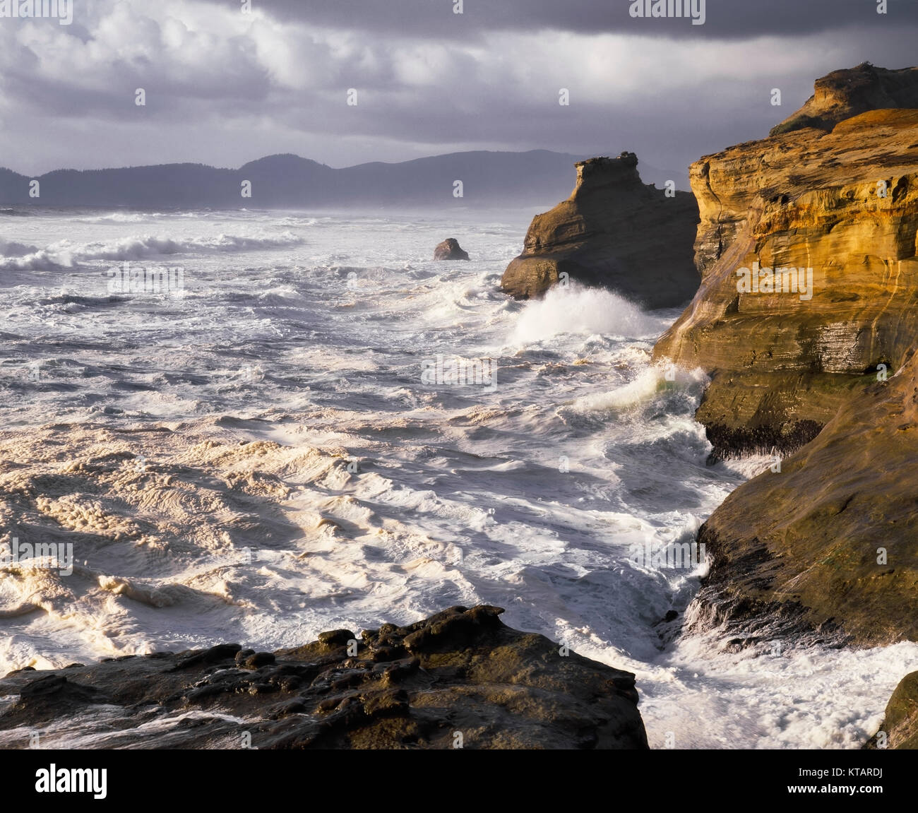 Luce della Sera calore sulla stormy surf a Cape Kiwanda parco dello stato su Oregon nord del litorale e di Tillamook County. Foto Stock