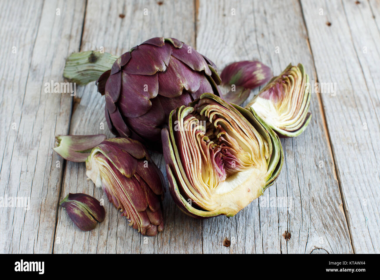 Carciofi romani su una tavola di legno Foto Stock