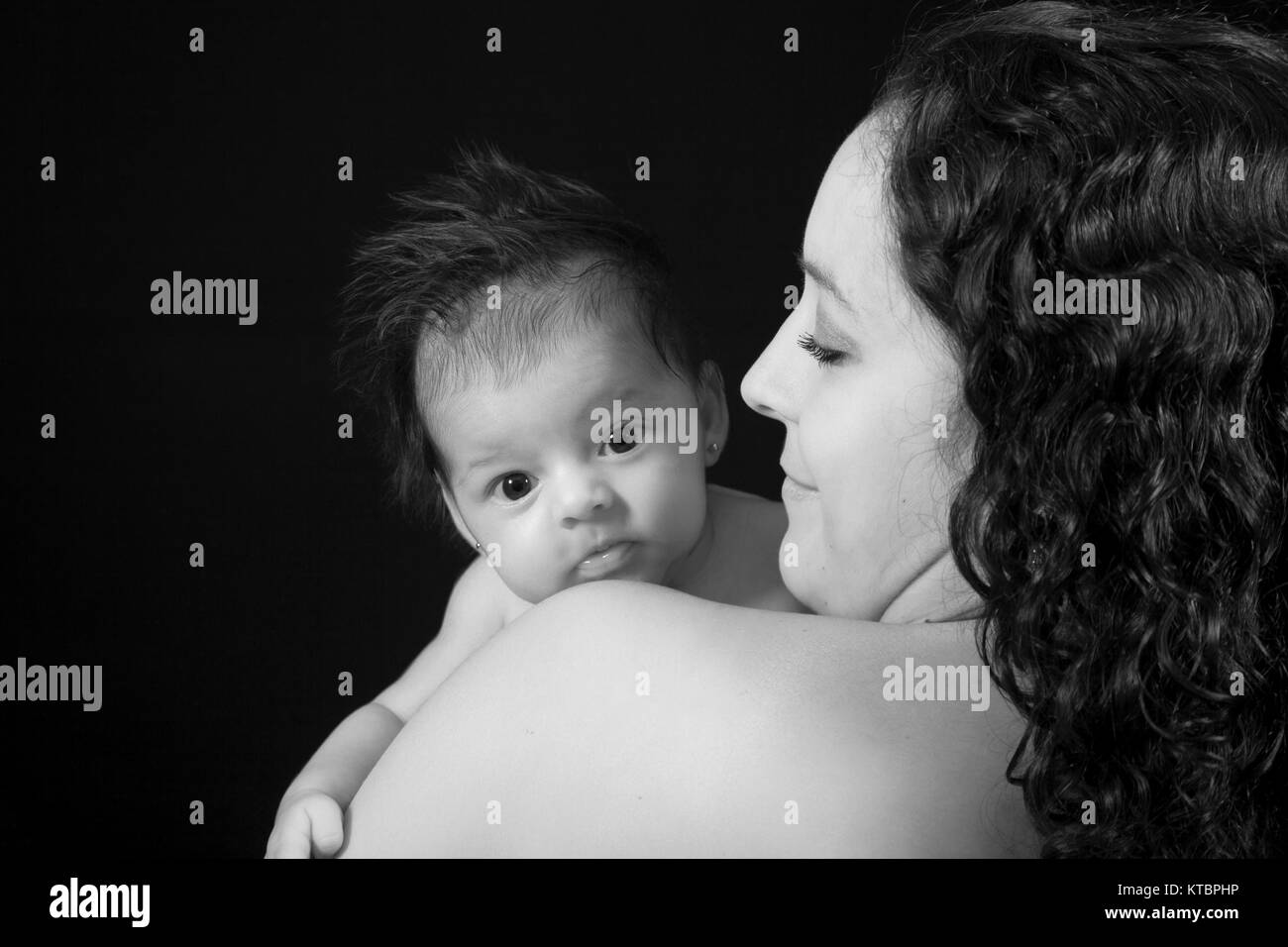 Madre con lei un mese Baby girl su sfondo nero Foto Stock