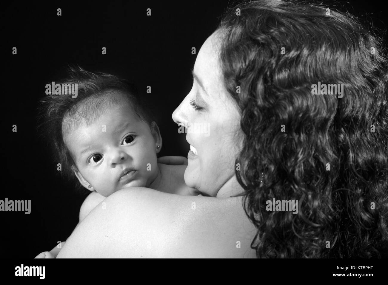 Madre con lei un mese Baby girl su sfondo nero Foto Stock