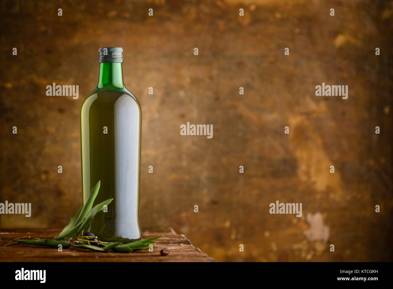 Olio di oliva Bottiglia con ramo sul tavolo di legno con lo spazio di copia Foto Stock