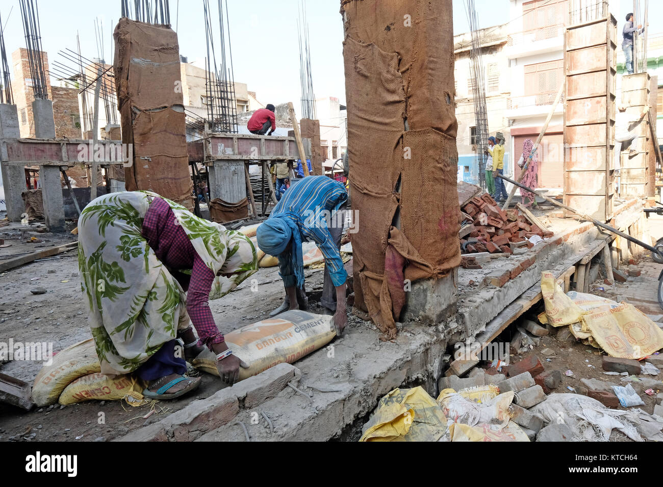 Un edificio sito in India con uomini e donne faticando Foto Stock