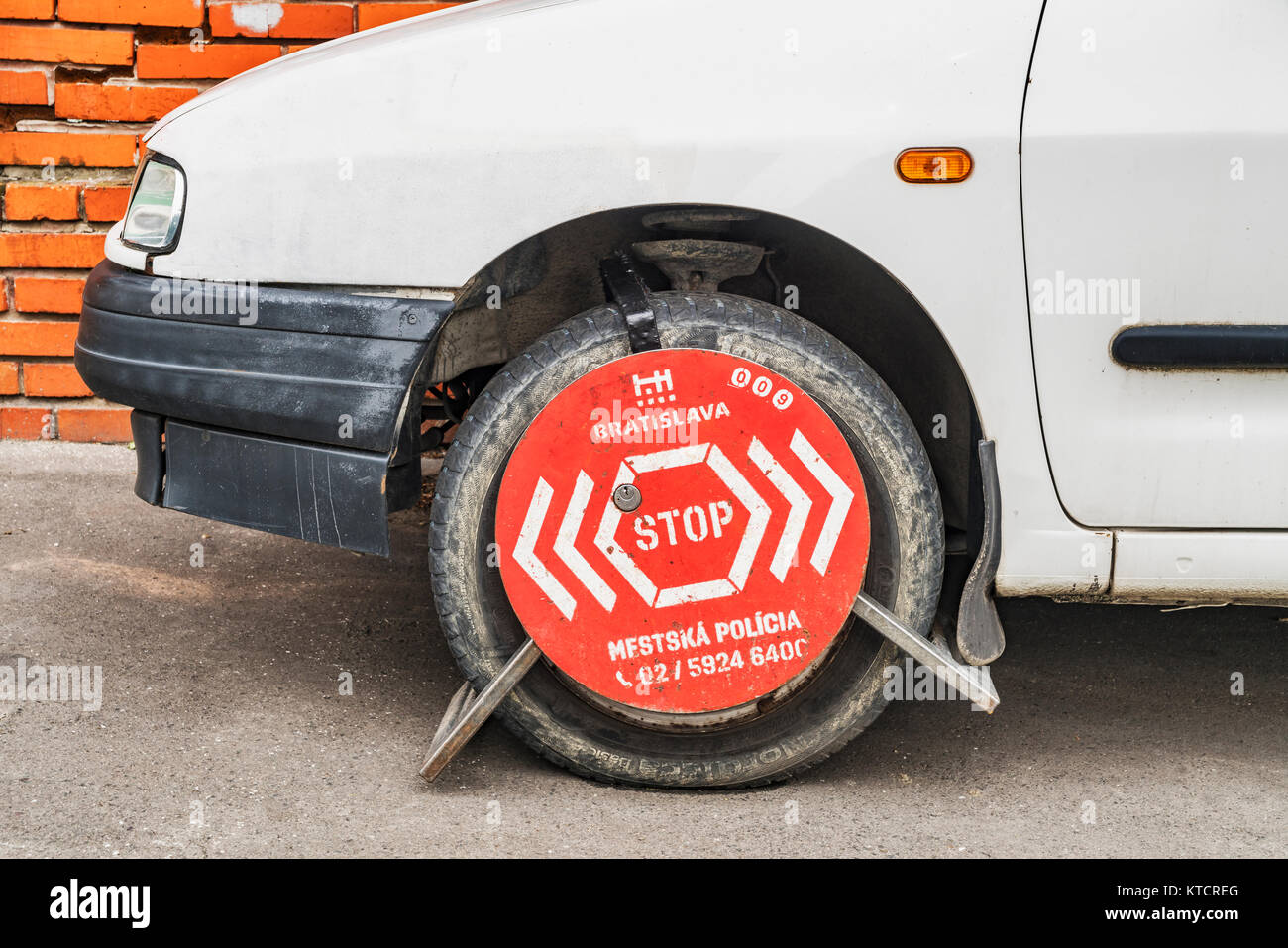 Un auto nel parcheggio zona di divieto è fissato con un morsetto di bloccaggio di ruota, Bratislava, Slovacchia, Europa Foto Stock