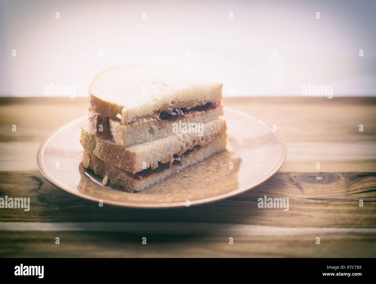 Burro di arachidi e gelatina in sandwich di pane bianco, tagliato a metà e impilati. Mostrato sulla piccola piastra vintage Foto Stock