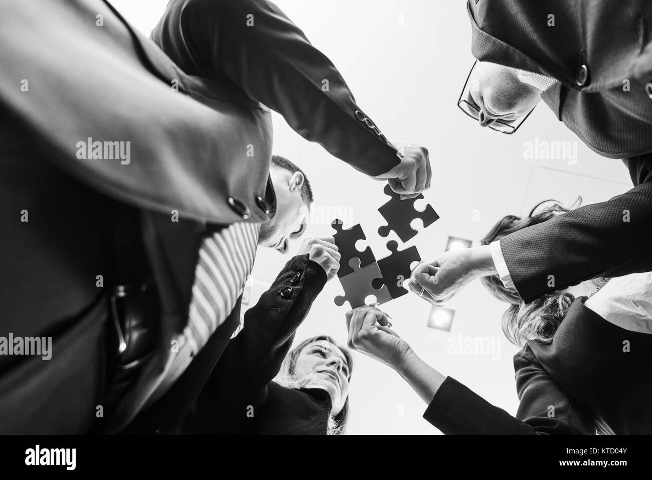 Un gruppo di persone di affari assemblaggio di puzzle e rappresentano il team di supporto e aiuto concetto in ufficio moderno Foto Stock