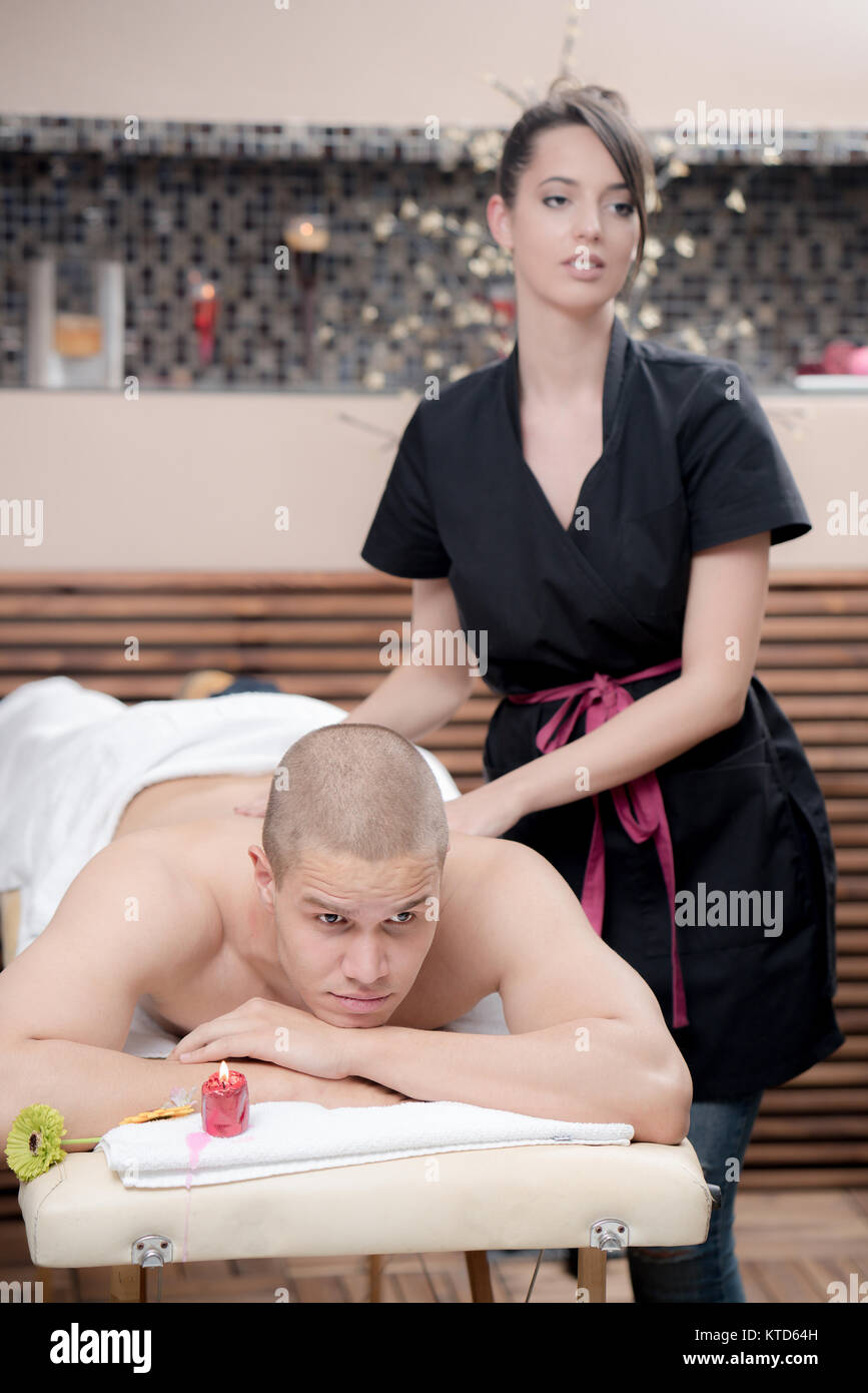 Massaggio sportivo. Terapista del massaggio massaggiare le spalle di un atleta maschio, lavorando con Trapezius muscolo. Immagine dai toni Foto Stock