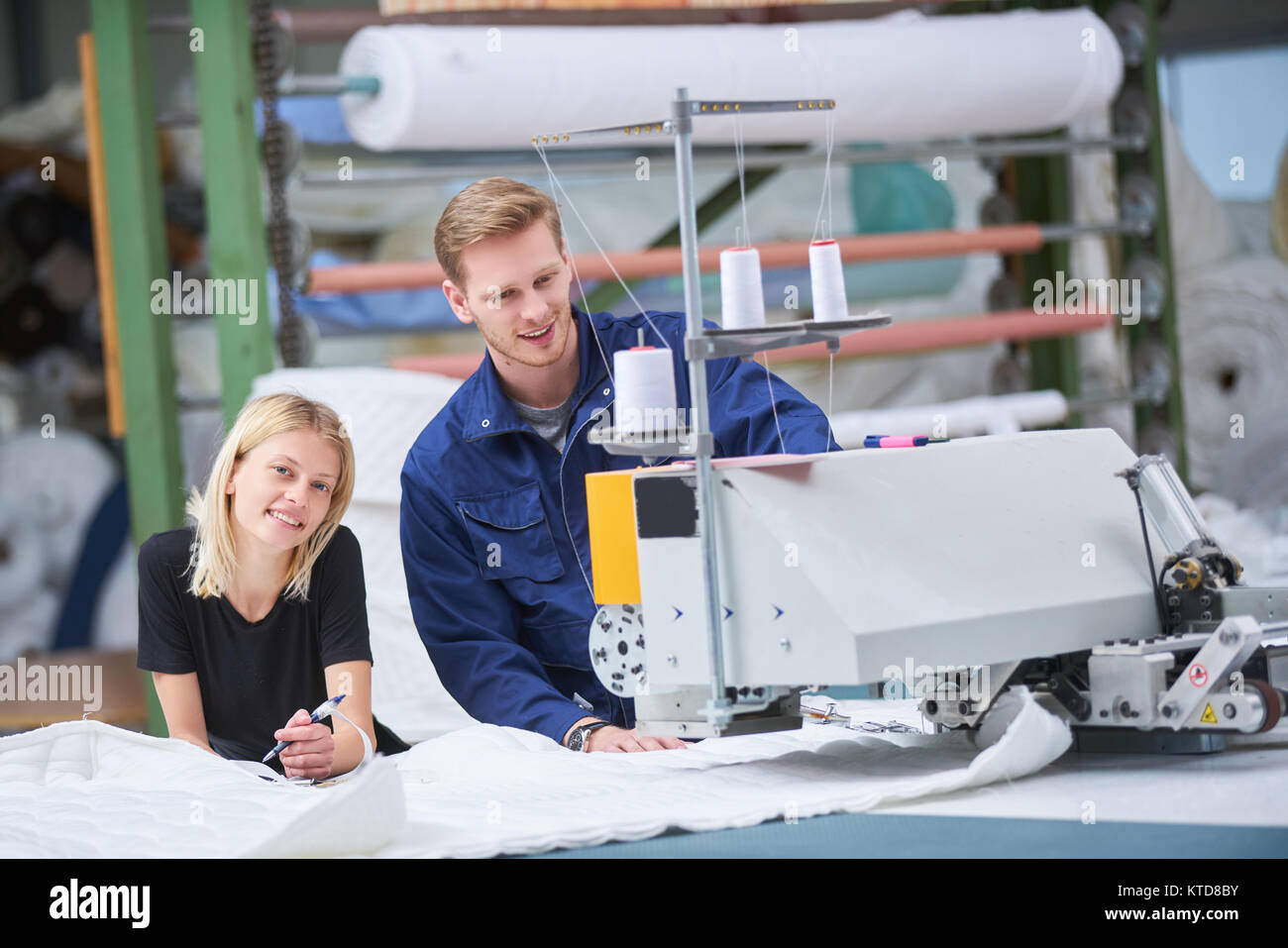 Sarta è nuovo assegnato ad una macchina in una fabbrica tessile, il caposquadra spiega qualcosa Foto Stock