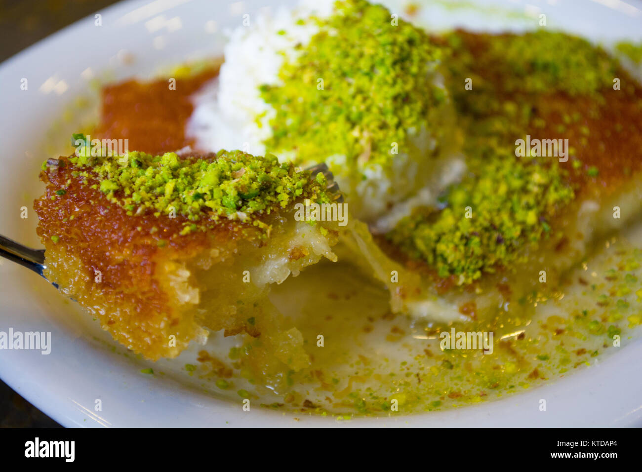 Dolce turco kunefe, kunafa, kadayif con polvere di pistacchi e formaggio hot mangiato un dolce Foto Stock