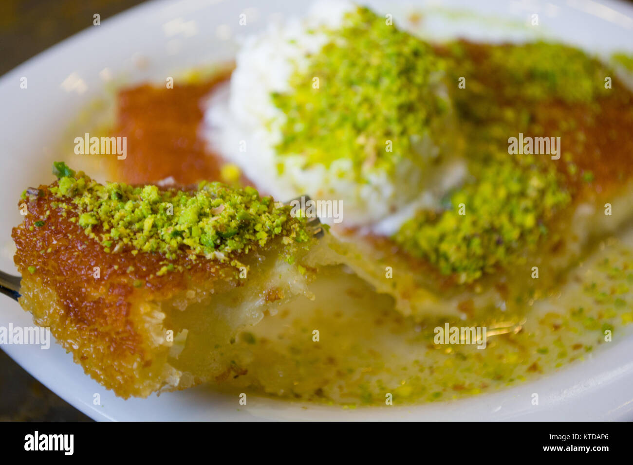 Dolce turco kunefe, kunafa, kadayif con polvere di pistacchi e formaggio hot mangiato un dolce Foto Stock