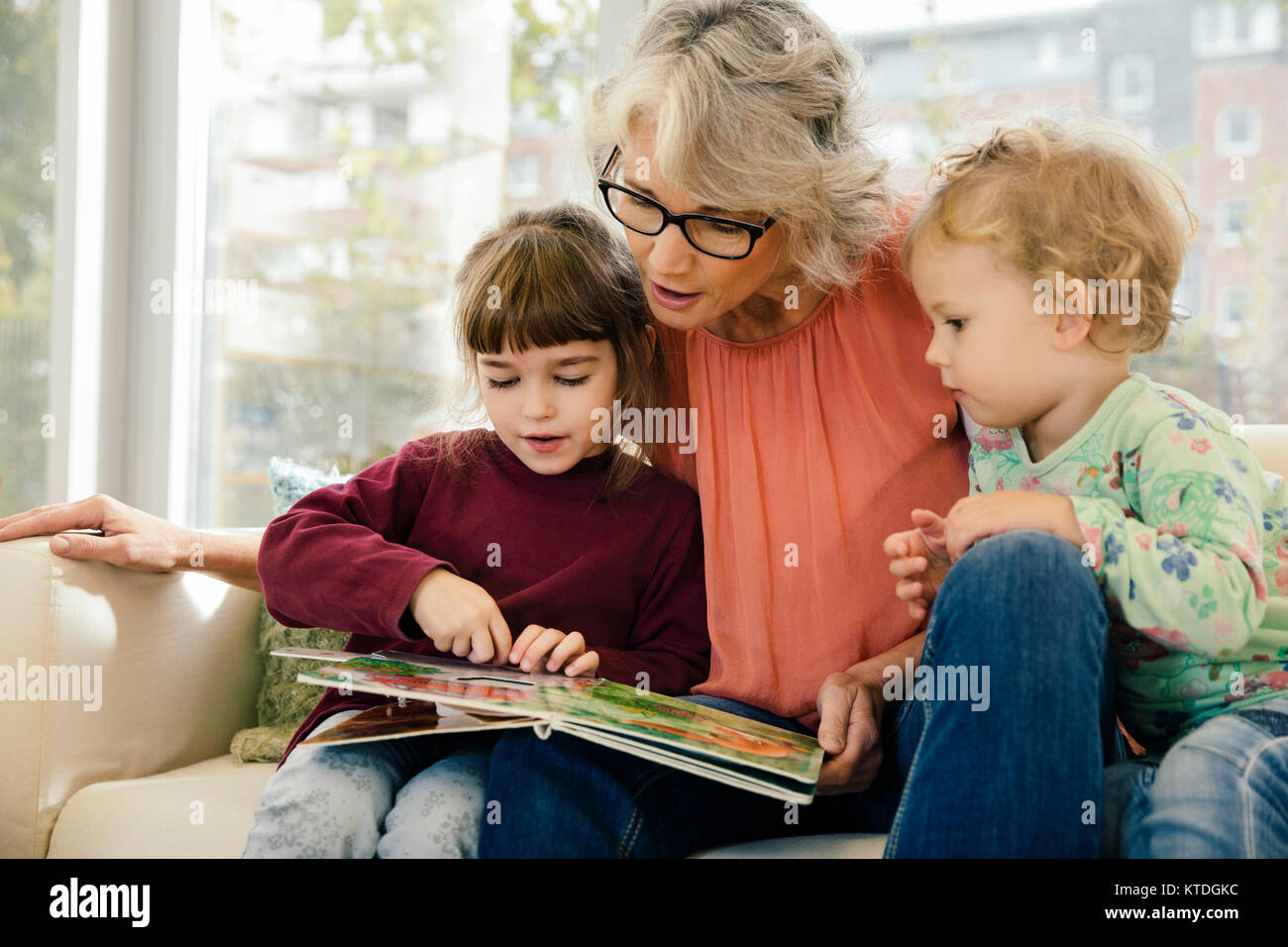 Pre-insegnante della scuola di lettura con i bambini in una scuola materna Foto Stock
