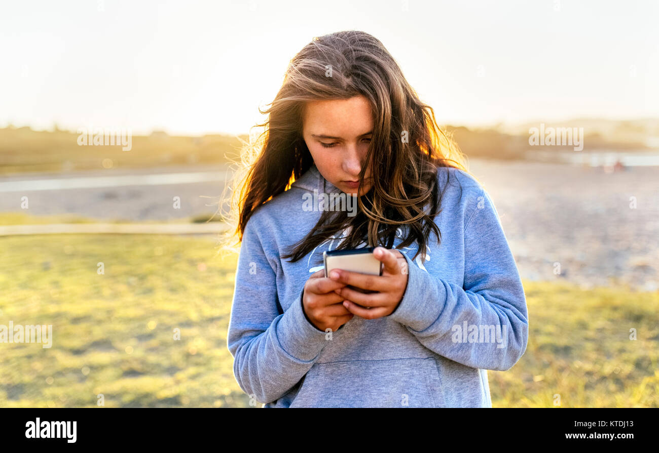 Ritratto di ragazza utilizzando il telefono cellulare all'aperto Foto Stock