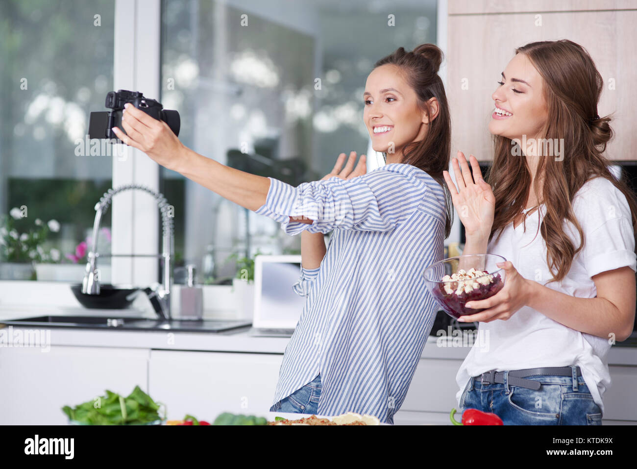 Blogger alimentare saluto loro telespettatori in cucina Foto Stock