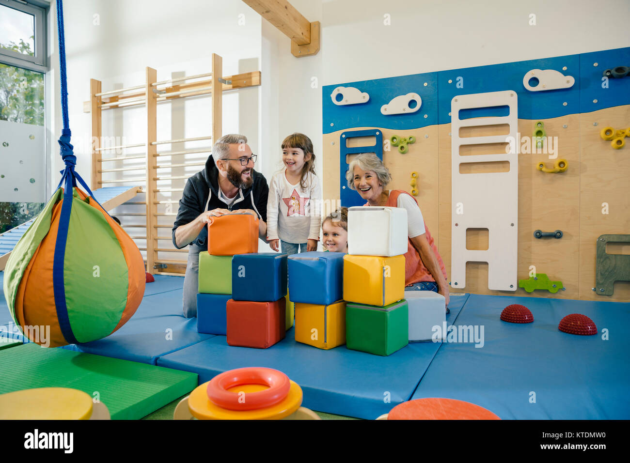 Felici i bambini e gli insegnanti in palestra nella scuola materna Foto Stock