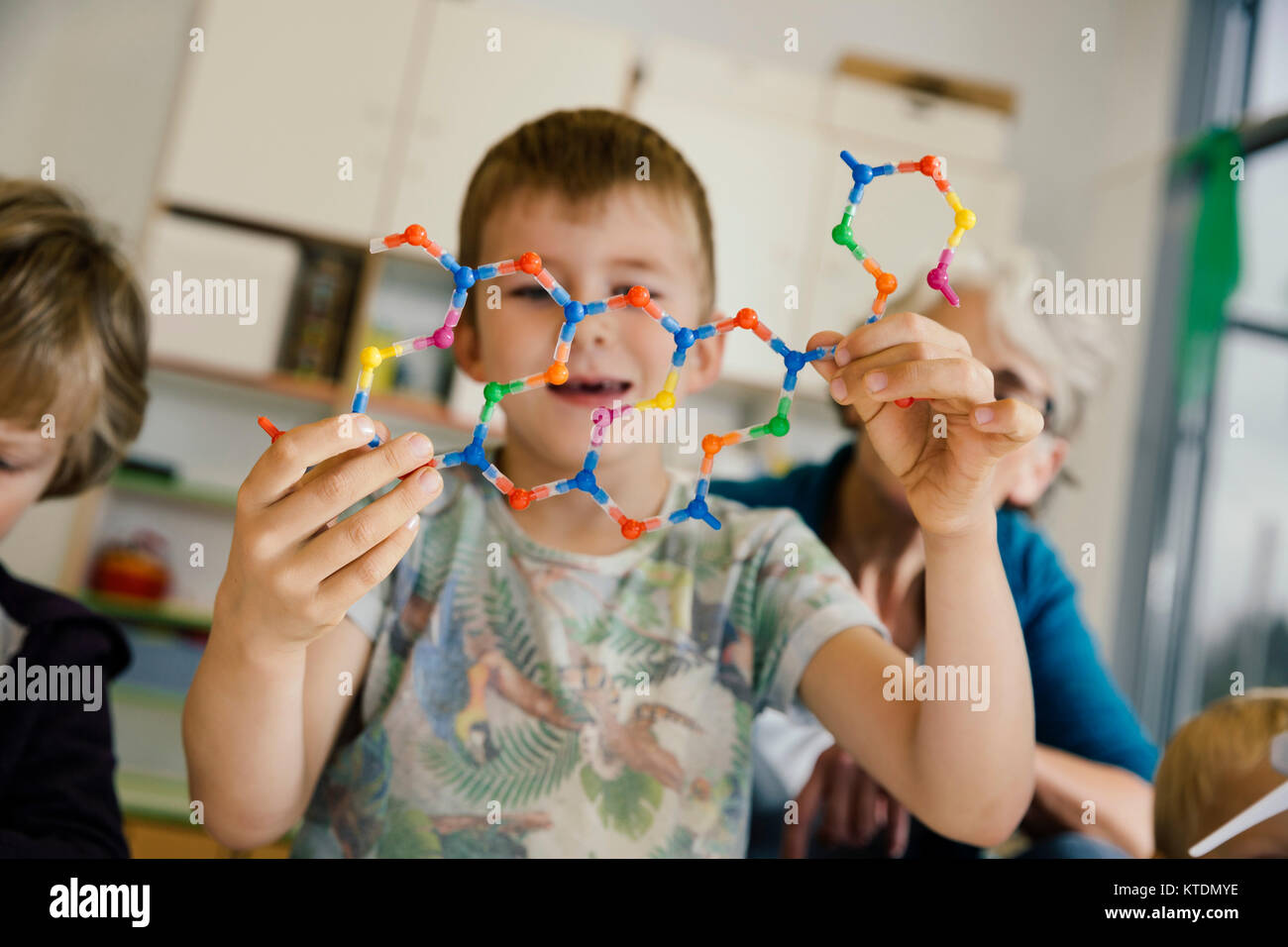 Ragazzo azienda elica di DNA modello in kindergarten Foto Stock