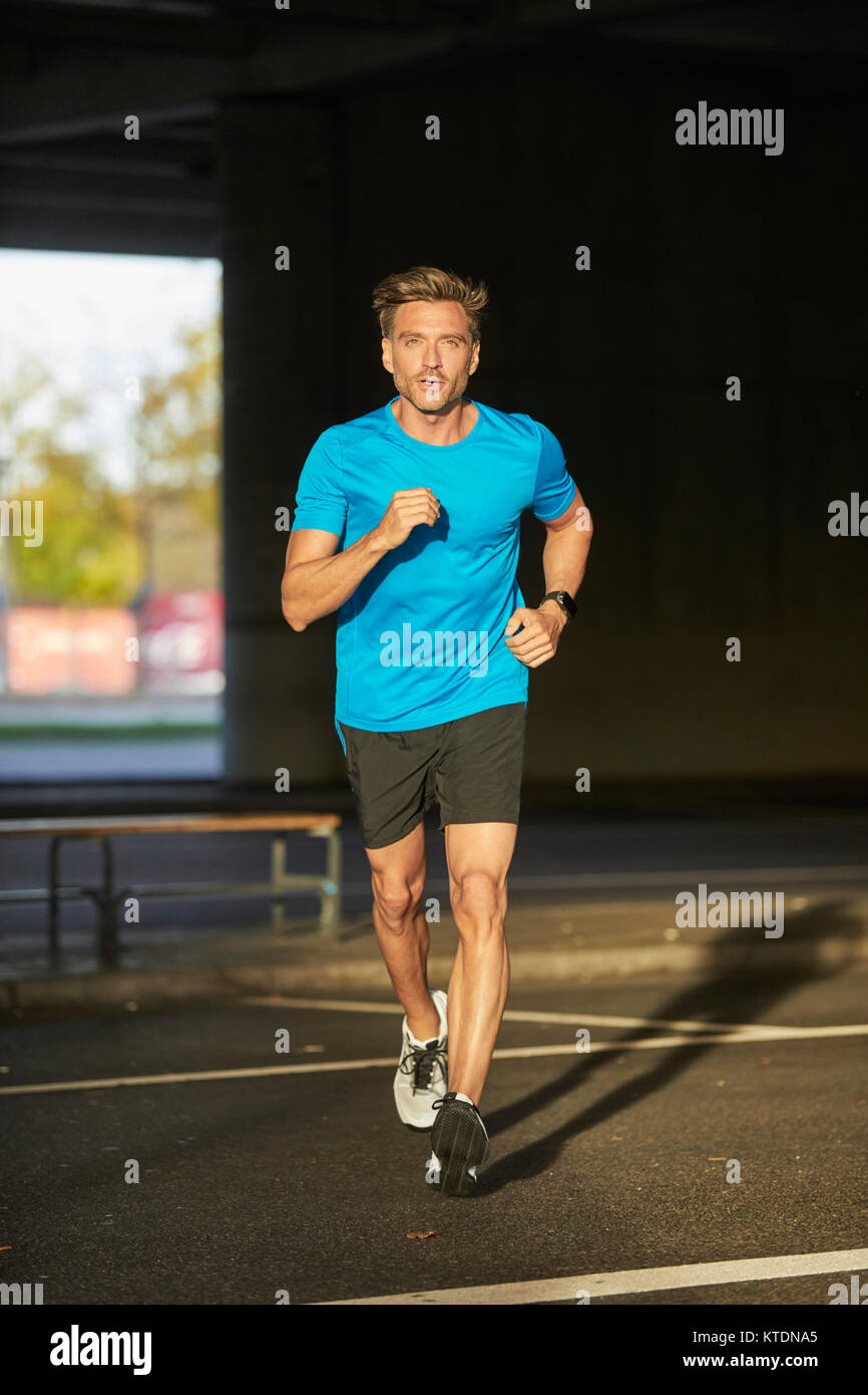 Uomo che corre nella città Foto Stock