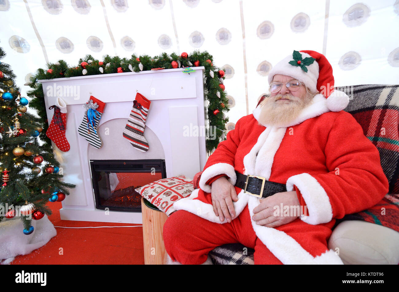 Babbo Natale seduto alla sua residenza durante il mercatino di Natale in piazza Contractovaya. Dicembre 20, 2017. A Kiev, Ucraina Foto Stock