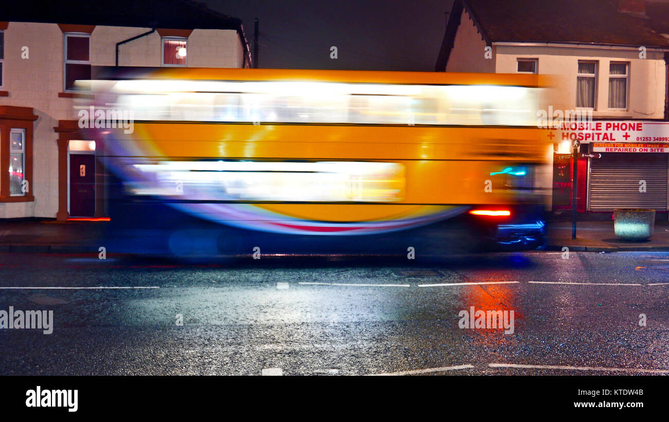 Viaggiare in autobus lungo la strada urbana di notte sotto la pioggia Foto Stock