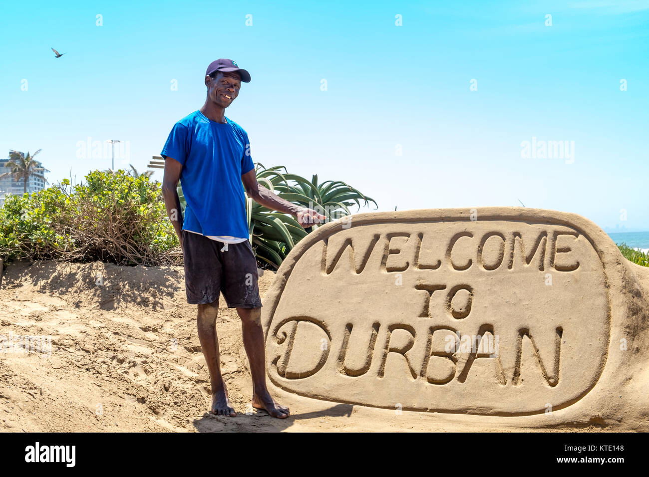 DURBAN, Sud Africa - 02 novembre 2017: sconosciuta la scultura di sabbia builder a bay abbondanza a Durban si erge accanto alla sua opera e punti a. Foto Stock