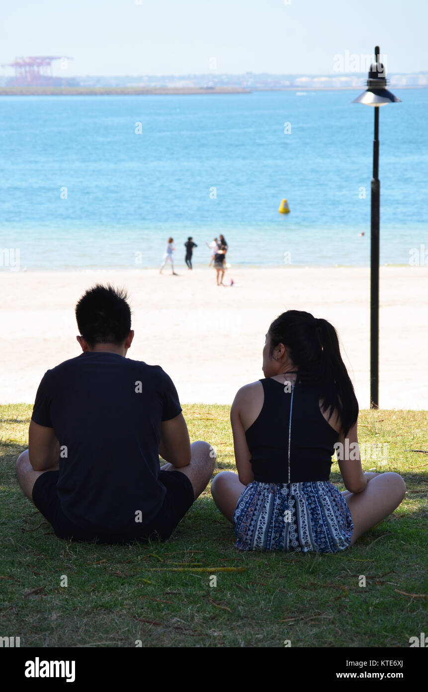 Giovani asiatici giovane seduti insieme a parlare Foto Stock