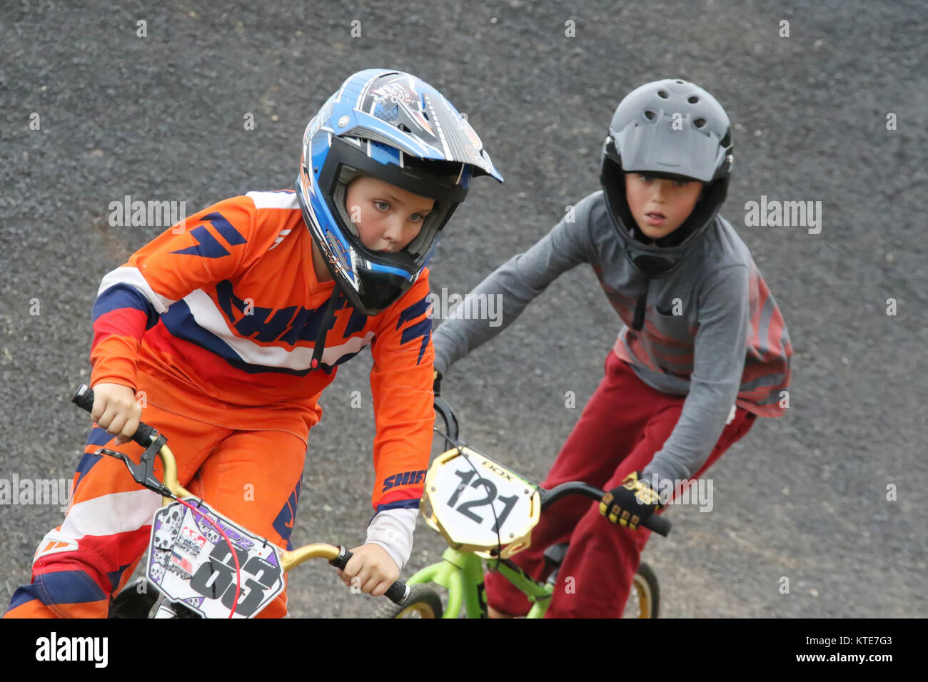 Ragazza Preteen conduce i ragazzi in una gara. Piloti a Kettering BMX gara in notturna. BMX via, Delco Park, Kettering, Dayton, Ohio, Stati Uniti d'America. Foto Stock