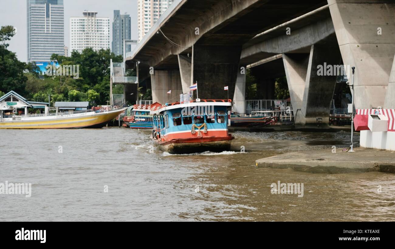 Traghetto passando sotto il Ponte Sathorn Fiume Chao Phraya con un atmosfera romantica Bangkok in Thailandia Foto Stock