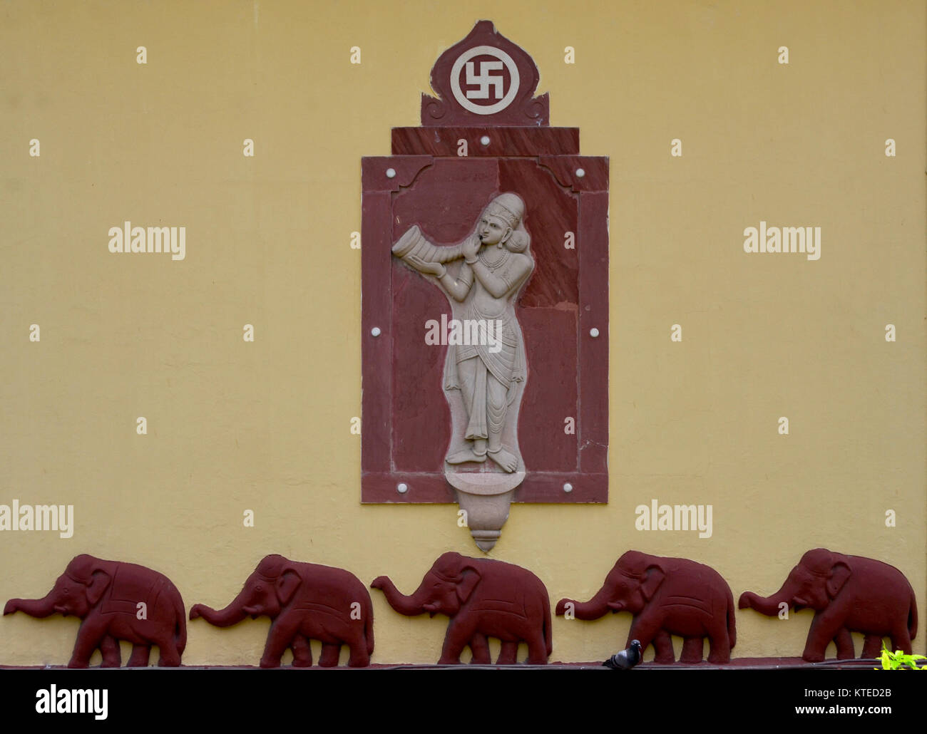 Gli elefanti e la svastica simbolo su un monumento al tempio indù Foto Stock