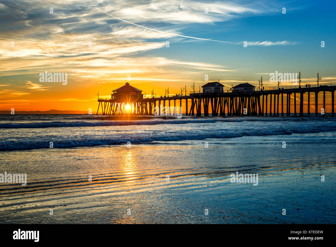 Paesaggio surreale come il sole tramonta sotto l'orizzonte lungo Huntington Beach, colata di un bagliore bellissimo e tranquillo paesaggio. Foto Stock