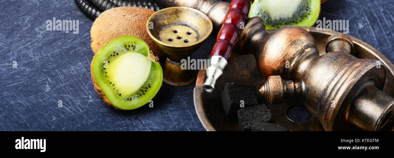 Fumare narghilè in stile arabo con l'aroma del tabacco kiwi Foto Stock